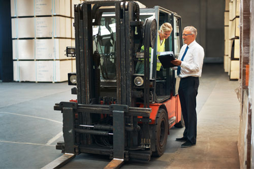 Operaria carretillera con gesor de almacén recibiendo indicaciones